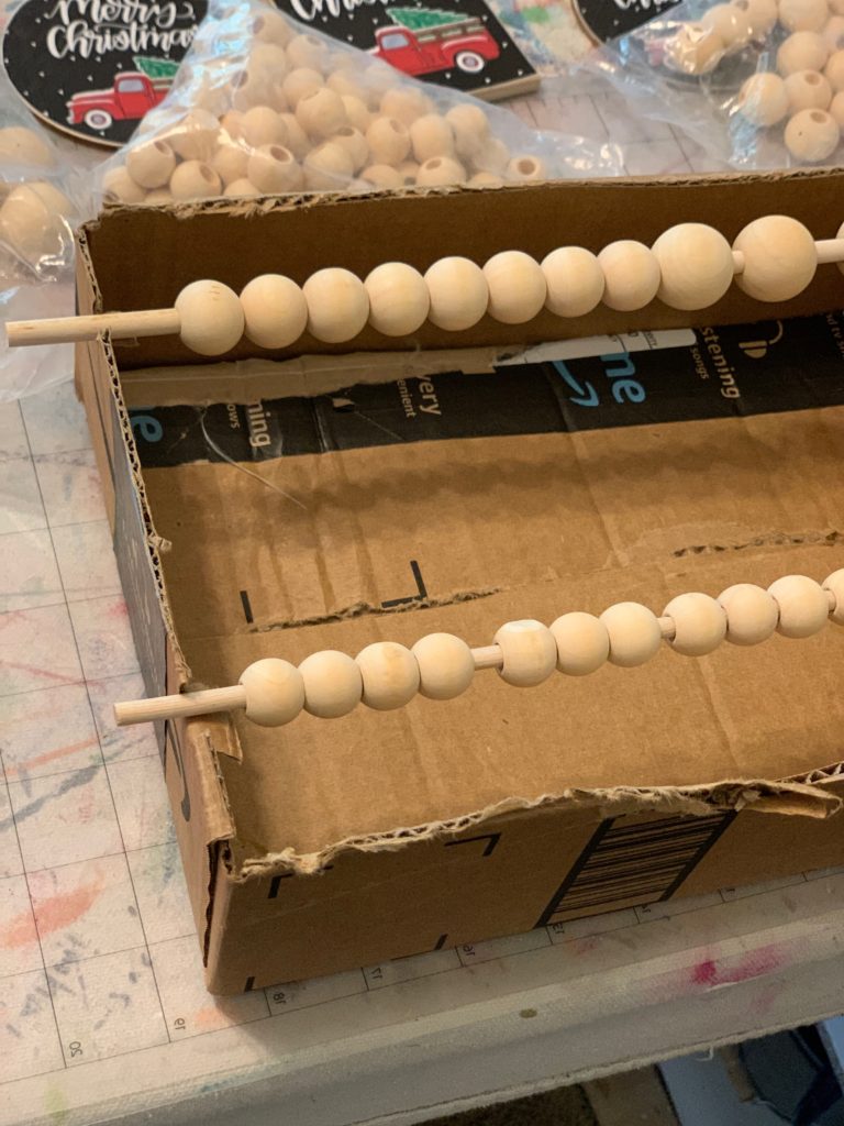 Step three: Place your sticks with the wooden beads placed on them into the square cutouts.